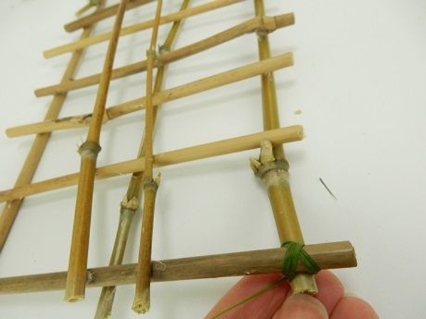Carefully latch the bamboo together with ripped grass Carefully latch the bamboo together with ripped grass