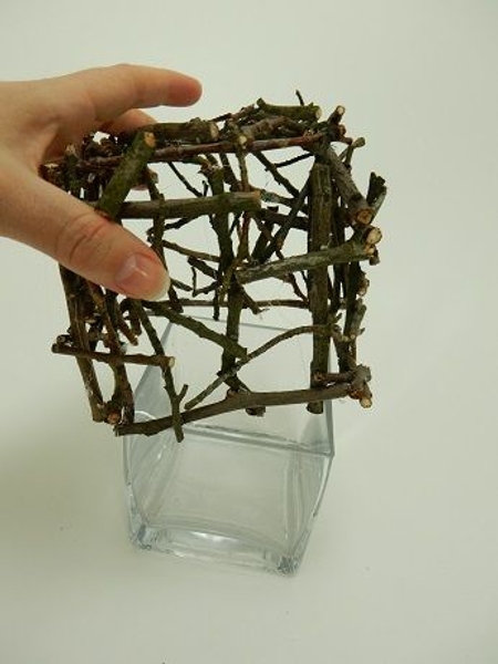 Slide the twig square over the cube vase. Slide the twig square over the cube vase.