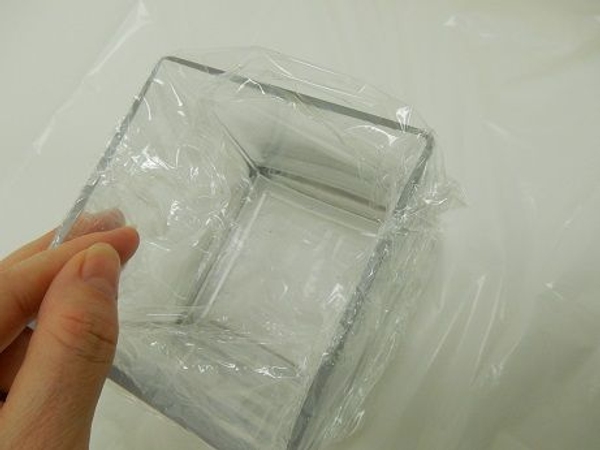 Turn the vase around and tuck the cling film into it Turn the vase around and tuck the cling film into it