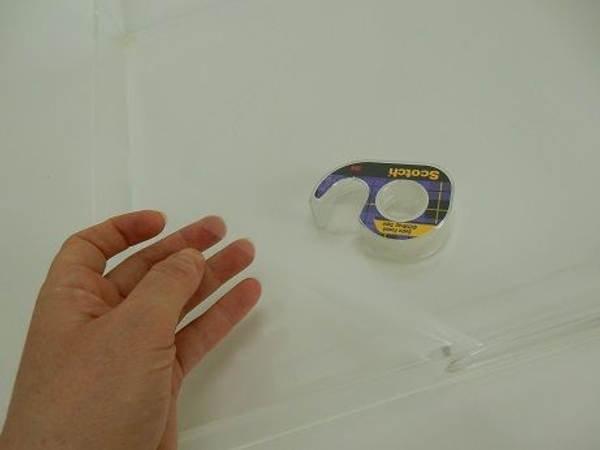 Cut sticky tape and fix two lengths from one side to the other over the clear vase Cut sticky tape and fix two lengths from one side to the other over the clear vase