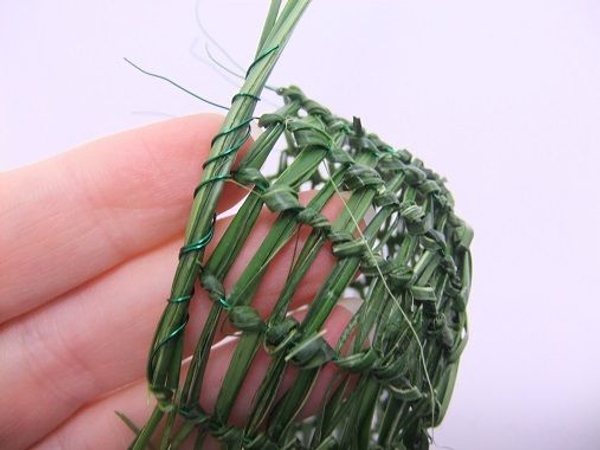 Fold the strands of grass and wire to the side and wrap the next wire around the strands Fold the strands of grass and wire to the side and wrap the next wire around the strands