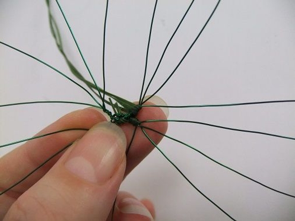 Fold the strands of grass behind the next wire and wrap Fold the strands of grass behind the next wire and wrap