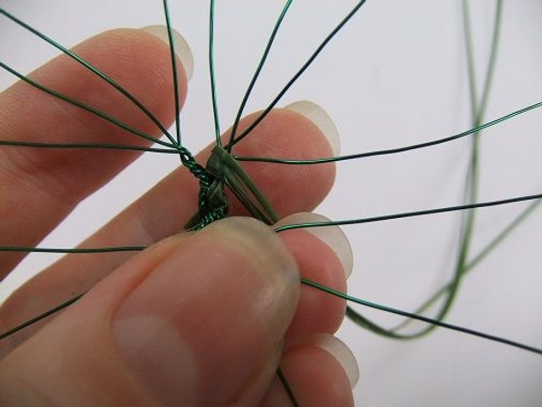 Fold the strands of grass behind the wire. Fold the strands of grass behind the wire.