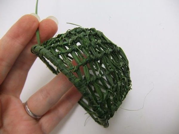 Neatly finish the design by wrapping a strand of grass to cover the wire around the rim Neatly finish the design by wrapping a strand of grass to cover the wire around the rim
