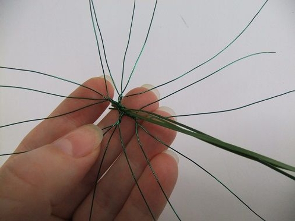 Press the end of a few strands of ripped leaf into a gap in the wire. Press the end of a few strands of ripped leaf into a gap in the wire.