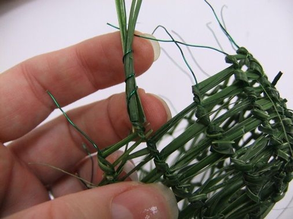 When the basket is high enough wrap the wire around the strands of grass When the basket is high enough wrap the wire around the strands of grass