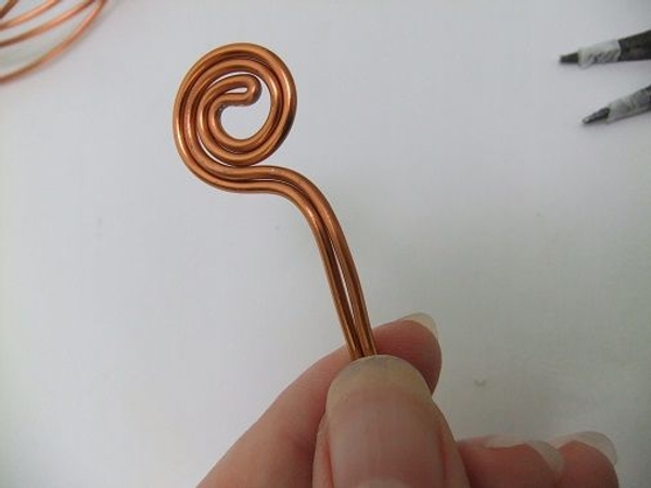 Extend the legs of the wire in parallel. Extend the legs of the wire in parallel.