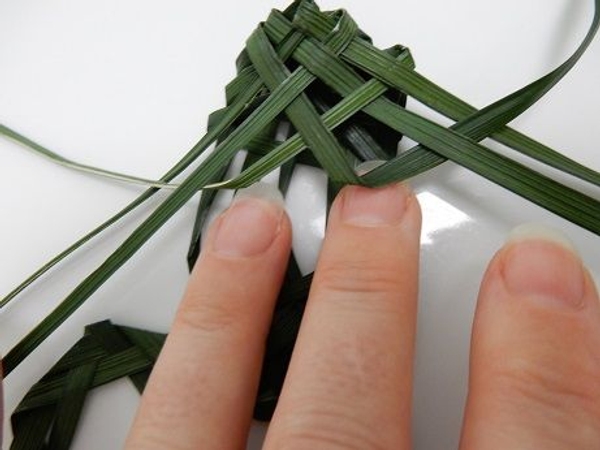 Start weaving the front leg by folding under the inside right blade Start weaving the front leg by folding under the inside right blade