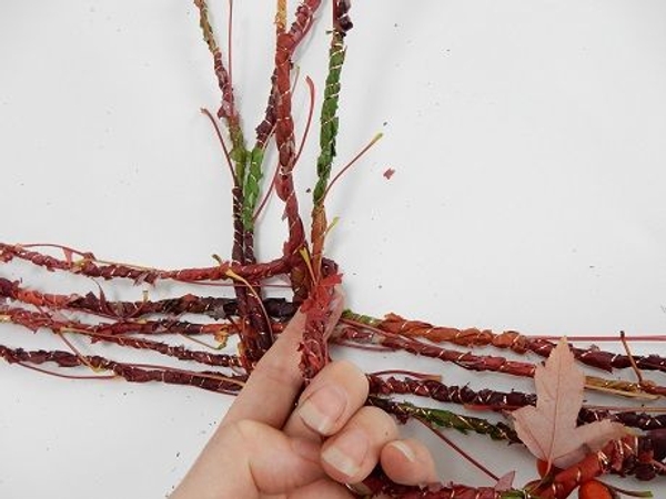 Bend the long side of the garland down to start the weave Bend the long side of the garland down to start the weave