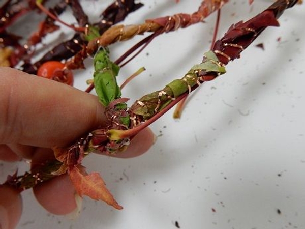 Fold the strand over the garland and secure with wire Fold the strand over the garland and secure with wire