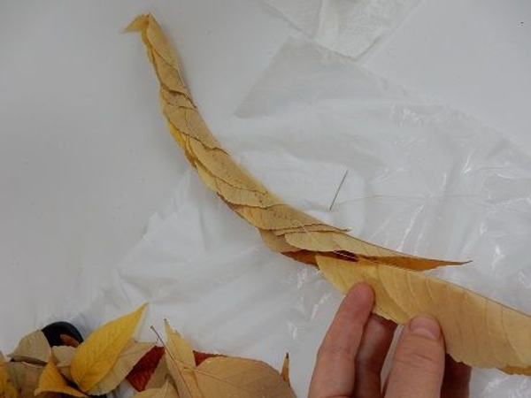 Keep nestling in leaves and stitching them together to create a long garland Keep nestling in leaves and stitching them together to create a long garland