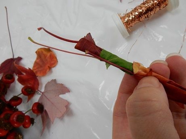 Place another leave over the first two leaves and wrap Place another leave over the first two leaves and wrap