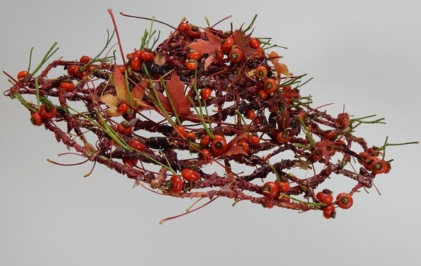 Weaving a hat from autumn leaves and rosehips with copper accents Weaving a hat from autumn leaves and rosehips with copper accents