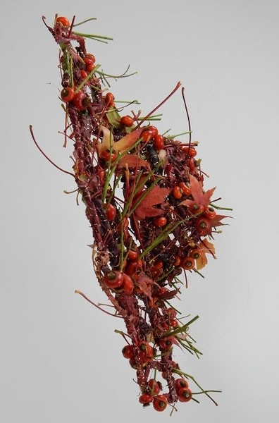 Weaving a hat with fall leaves and rose hips