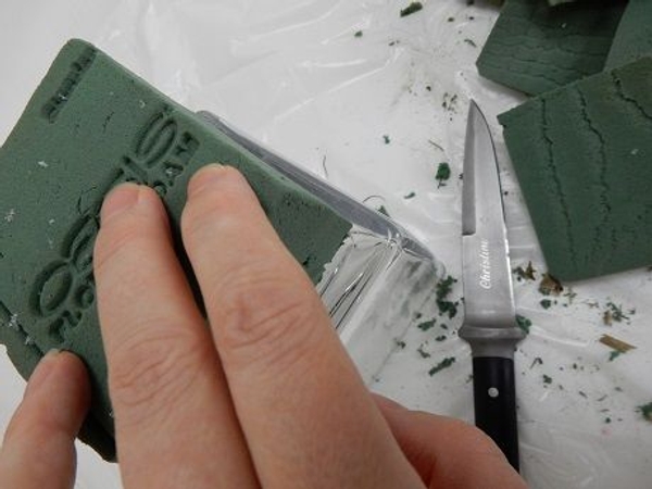 Cut a block of floral foam into a square Cut a block of floral foam into a square