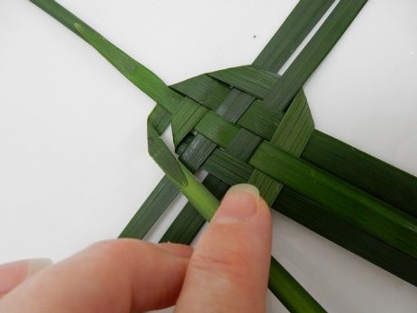 Fold it over and weave it through the three leaves in the bottom Fold it over and weave it through the three leaves in the bottom
