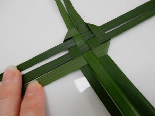 Fold the leaf again and weave over and under the next set of leaves. Fold the leaf again and weave over and under the next set of leaves.