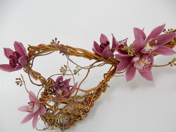 Cymbidium orchids, eucalyptus capsules woven into a willow wand Cymbidium orchids, eucalyptus capsules woven into a willow wand