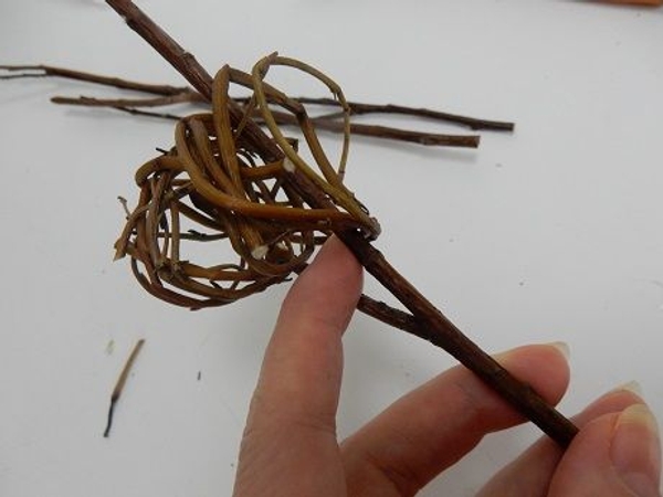 Hook the twilrled willow tube through the twig so that it rests in the natural fork Hook the twilrled willow tube through the twig so that it rests in the natural fork
