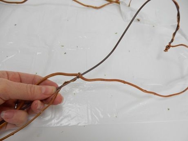 Knot a new willow stem at the end of the heart and weave it around the candle part of the wand Knot a new willow stem at the end of the heart and weave it around the candle part of the wand
