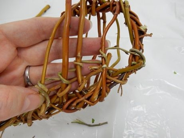 Wrap a new twig next to the first one to build up the basket Wrap a new twig next to the first one to build up the basket
