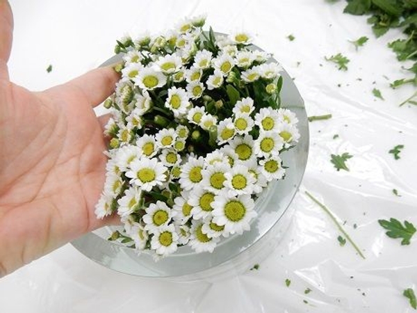 Keep the twigs in place with your hand and set the vase upright. Keep the twigs in place with your hand and set the vase upright.