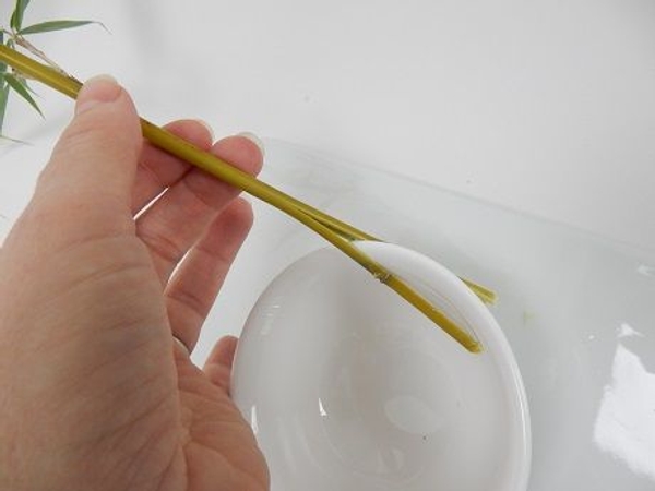 Tilt the bamboo stems to the side to create a gapfor the flower stem Tilt the bamboo stems to the side to create a gapfor the flower stem