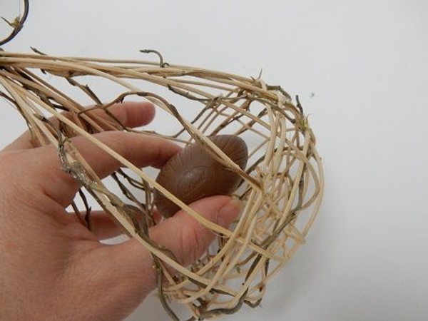 Slip the chocolate eggs into the nest basket Slip the chocolate eggs into the nest basket