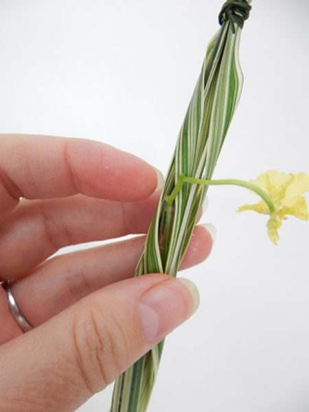 Place the flower in a tiny water tube and conceal inside the grass bundle