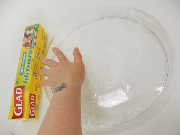 Cover a disk shaped bowl with wrap to protect it Cover a disk shaped bowl with wrap to protect it