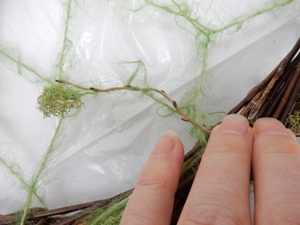 Weave in thin willow stems following the wool pattern