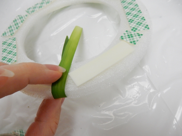 Remove the tape cover to expose the sticky side and fold a blade of grass to stick to both sides Remove the tape cover to expose the sticky side and fold a blade of grass to stick to both sides