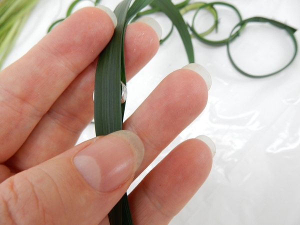 Carefully smooth another blade of grass over the magnet