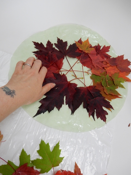 Glue the leaves to the paper leaving the middle section empty Glue the leaves to the paper leaving the middle section empty