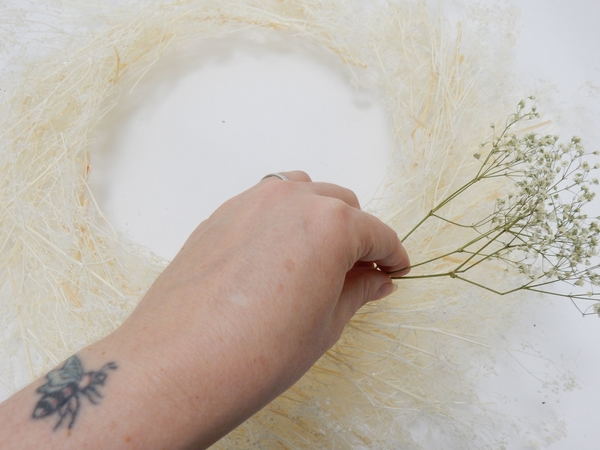 Place the wreath on a flat working surface and glue a snippet of dried Gyp to follow the shape Place the wreath on a flat working surface and glue a snippet of dried Gyp to follow the shape