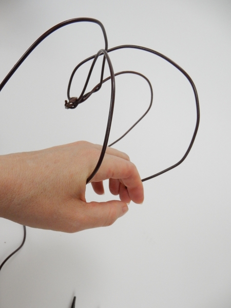Bend the wire in the middle point and curve it round the back to fill out the heart shape Bend the wire in the middle point and curve it round the back to fill out the heart shape