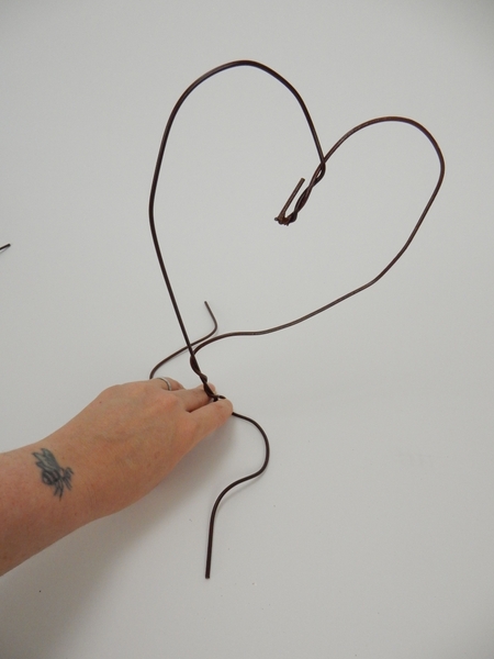 Bend the wires open and curve to create two flat legs for the shape to rest on Bend the wires open and curve to create two flat legs for the shape to rest on