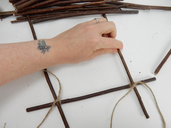 Secure two twigs with a knot to this first twig Secure two twigs with a knot to this first twig