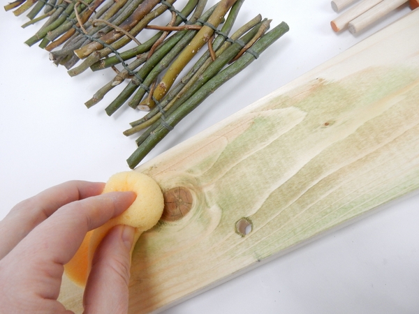 Wash the wood with a wet brush dipped in a weak mixture of paint or vegetable stain Wash the wood with a wet brush dipped in a weak mixture of paint or vegetable stain