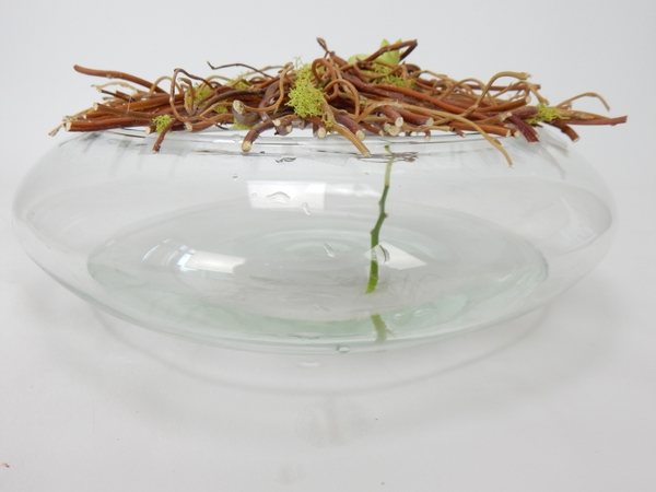 Fill the container with water and insert the flowering stem through the grid Fill the container with water and insert the flowering stem through the grid