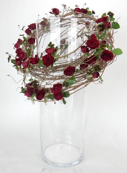 Hang a grape vine wreath around a vase as an armature Hang a grape vine wreath around a vase as an armature