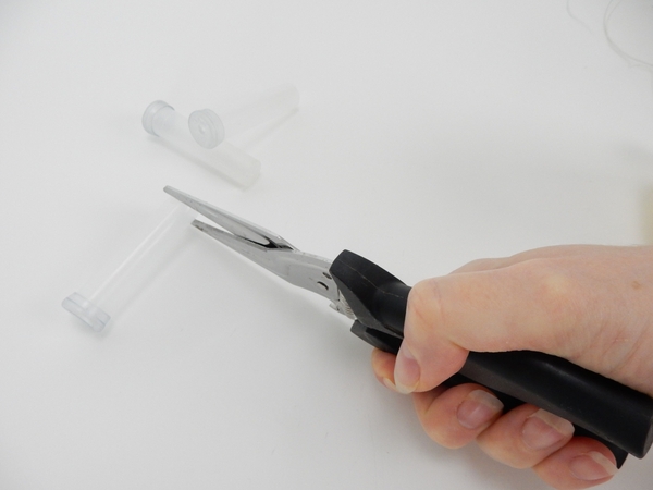 Snip the closed bottom of a plastic vial Snip the closed bottom of a plastic vial