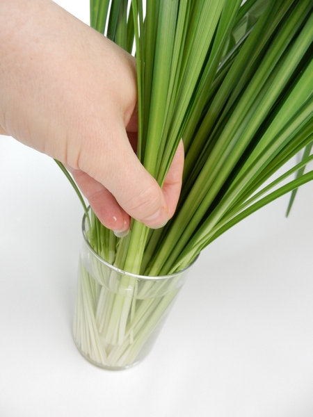 Keep adding bundles of grass to almost fill the vase Keep adding bundles of grass to almost fill the vase