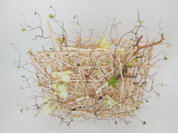 Phalaenopsis orchids, ivy, willow and grape vine tendrils on a popsicle stick armature floral art design Phalaenopsis orchids, ivy, willow and grape vine tendrils on a popsicle stick armature floral art design
