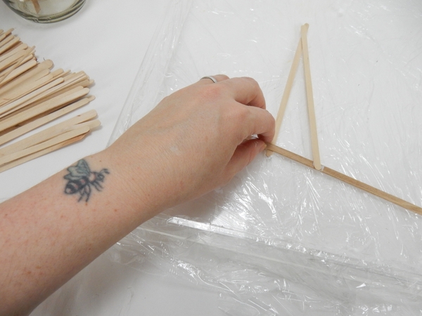 Set the Popsicle sticks in the tray and secure with wood glue in a random overlapping pattern Set the Popsicle sticks in the tray and secure with wood glue in a random overlapping pattern