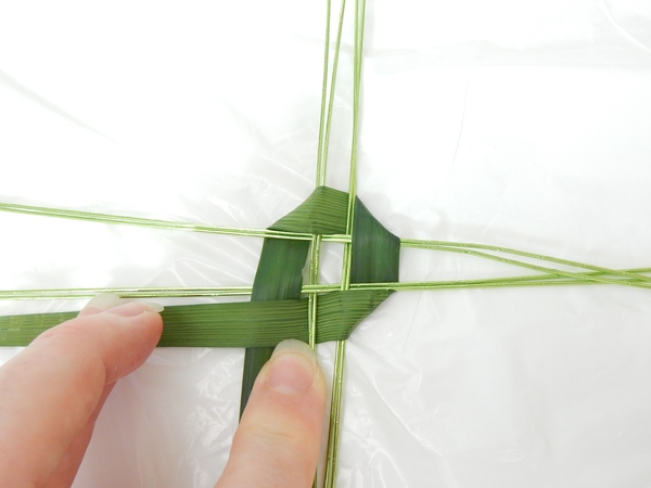 Continue the weaving pattern around the strands. Include the new strand that was created with the garland Continue the weaving pattern around the strands. Include the new strand that was created with the garland