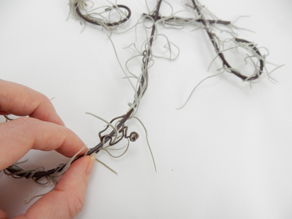 Glue in some of the grape vine tendrils with florist glue Glue in some of the grape vine tendrils with florist glue