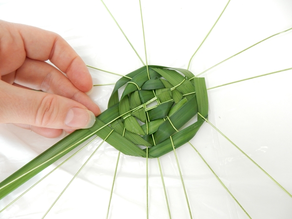 Weave the garland of grass over or under every wire following the basic weaving pattern Weave the garland of grass over or under every wire following the basic weaving pattern