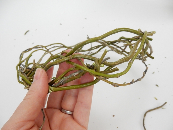 Remove the elastic band and weave the two ends together to connect the willow crown. Remove the elastic band and weave the two ends together to connect the willow crown.