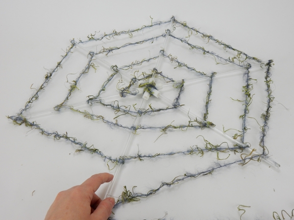 Secure the wool to the rod with a knot and place it in the twig tangle Secure the wool to the rod with a knot and place it in the twig tangle